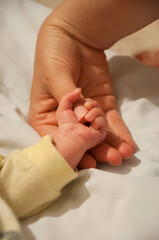 Mother holding baby's hand after birth