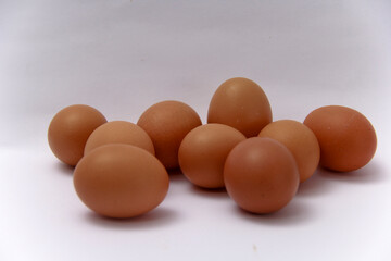 eggs sits on a wooden table. The eggs are brown and appear to be fresh. The basket is woven and has a black cloth draped over it. Concept of warmth and comfort