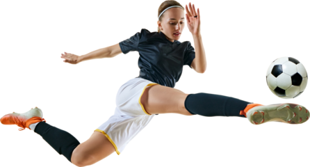 Young athletic woman, professional football player kicking ball in motion in mid-jump against transparent background. Concept of sport, competition, tournament, games, event.
