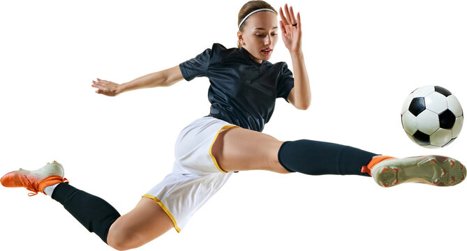 Young athletic woman, professional football player kicking ball in motion in mid-jump against transparent background. Concept of sport, competition, tournament, games, event.