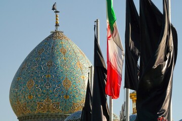 Iranian and Shia flags. Mosque dome decorated with colorful ceramic tiles in Shiraz, Iran © Xavier Allard