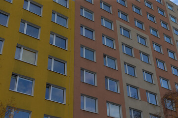 A vibrant and colorful facade of an apartment building, showcasing an array of multiple windows prominently