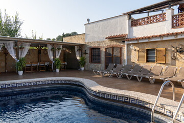 Serenity by the pool: a cozy deck, shaded patio, and beautiful villa create the ideal setting for relaxation and leisure