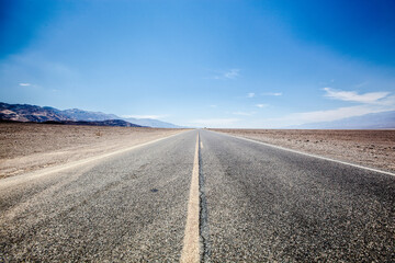 Straight empty road in Death Valley National Park , Nevada , USA