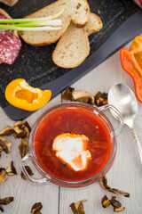Lenten borscht with dried mushrooms and vegetables, on a light wooden table