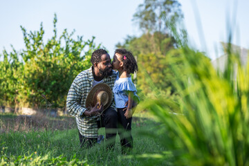 Father and Daughter Sharing a Sweet Moment in the Field, Embracing Love and Connection in Nature, Greenhouse Background, Family Bond, Rural Life, Happy Memories on a Beautiful Sunny Day