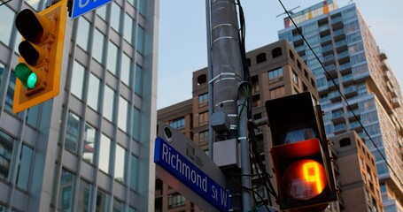 Traffic light on busy Richmond Street in downtown Toronto, Modern cityscape of Toronto with...
