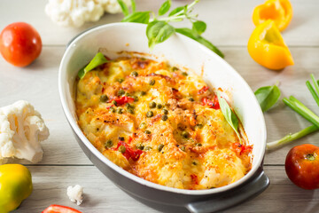cauliflower baked with sweet pepper and vegetables under cheese
