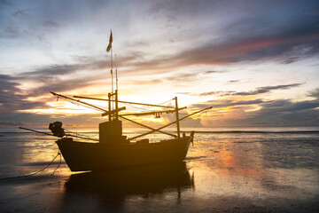 Naklejka premium sunset over the sea with fishing boat