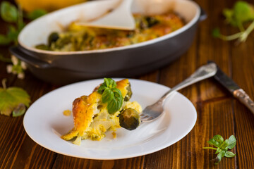 cauliflower and brussel sprouts casserole with cheese, in a plate on a wooden table