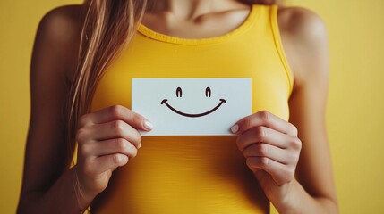 Woman holding a smiley card, symbolizing happiness and stress relief.