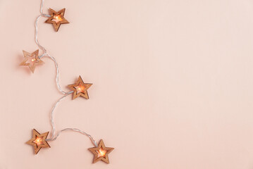 Christmas holidays background with Christmas lights on pink background. Top view