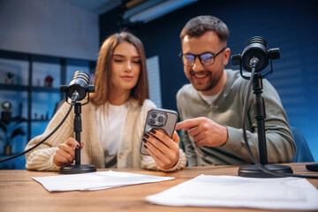 Man and woman are sitting. Radio hosts recording podcast