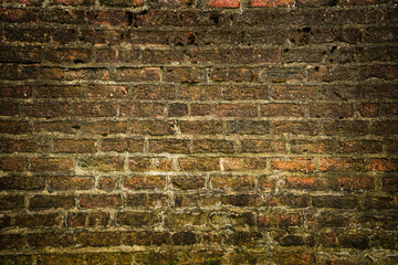 Dark brick wall in red tones in a ruined house. Concept textures and backgrounds