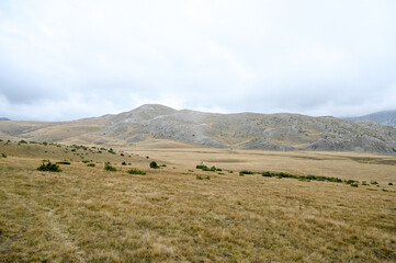 Obraz premium Mountain plateau in autumn. Clouds and fog above the mountain. 