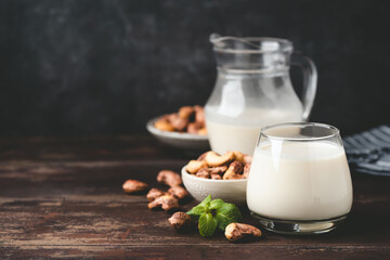 Lactose free Cashew milk on wooden table, vegetarian organic healthy food choice. Copy space for text or design elements