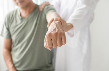 Female physiotherapists provide physical assistance to male patients with shoulder injuries massaging their shoulders for muscle recovery in the rehabilitation center. Physiotherapy concepts