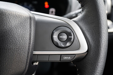 Close-up view of a modern car steering wheel with various driver control buttons