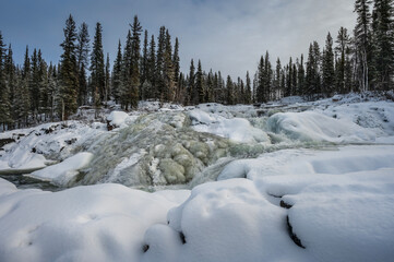 Winter view of the frozen Cameron River Rampart Falls near Yellowknife in Hidden Lake Territorial Park, Northwest Territories, Canada