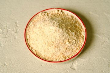 Ground garlic neatly arranged on a small ceramic plate, placed on a light surface.