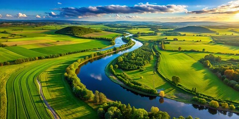 Obraz premium Aerial View of a Serene Landscape with Lush Green Fields and a Meandering River Ideal for Free Use in Commercial Projects
