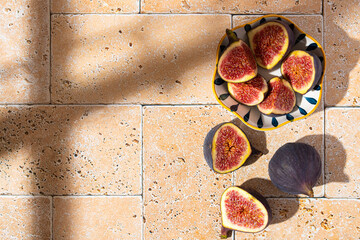 Sliced figs in a porcelain plate on the table. Top view