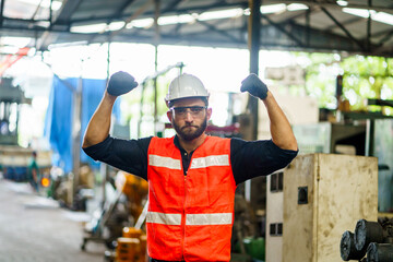 Portrait of confidence Industry Engineer and hard hat standing flexing muscles Showing biceps strong power to working in Factory . worker or labor beard man employee wearing uniform in manufacturing