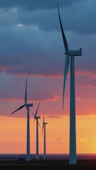 A wind power plant featuring spinning turbines beneath a vivid sunset symbolizing sustainable energy production
