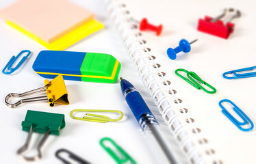 Colorful stationery items including an eraser, paper clips, and a notebook are arranged on a workspace ready for study or organization tasks