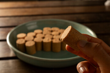 A guy's hand taking one Sweet Brazilian Peanut Called Paçoca