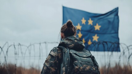 Female soldier with EU flag in barbed wire setting