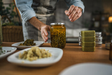 Adult man herbalist prepare natural oils in a rustic kitchen setting