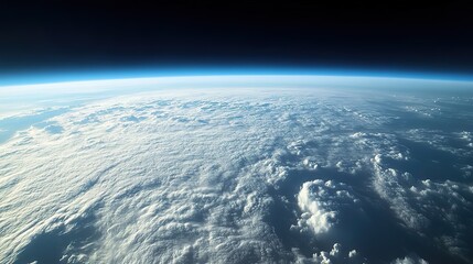 Stunning view of Earth from space, showing a layer of clouds and the curvature of the planet against the blackness of space.
