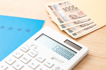 130万と表示された電卓と年金手帳