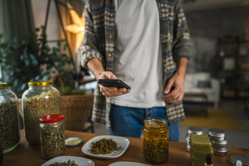 close up of adult man take a photo of herbs from plate with cellphone