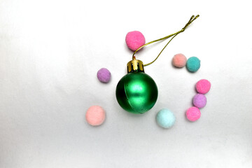 On a gray background, a Christmas tree decoration, a green glass ball. Merry Christmas greeting card.