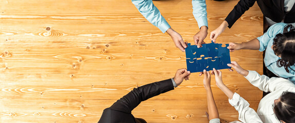 Multiethnic business people holding jigsaw pieces and merge them together as effective solution...