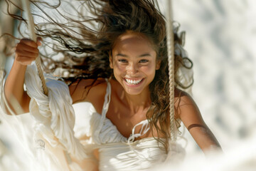 Close up portrait of a young woman wearing white dress swinging in a swing