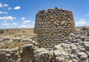 Majestic ruins of nuraghe Piscu in sardinia, italy, stand tall against a vibrant blue sky,...