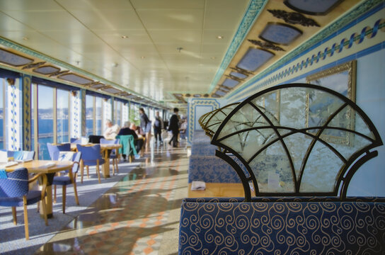 Modern kitschy loud interior design inside buffet self-service restaurant onboard luxury cruiseship cruise ship ocean liner with tables, chairs and casual dining atmosphere hallway service stations