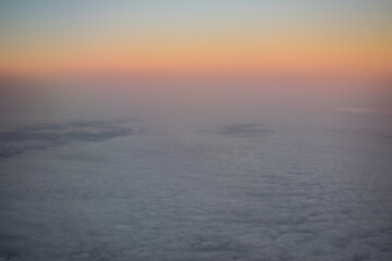 a dawn above the clouds through the porthole