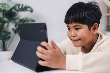 Asian boy student using tablet learning, Educational of tech concept, Staying at home, Presenting a modern educational way of life, Virtual internet online class from school teacher.