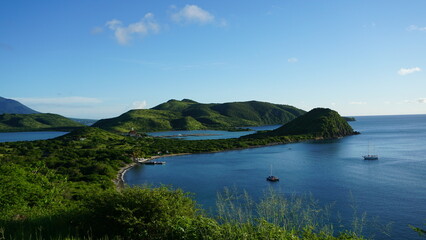 View of lush rainforest covered rolling hills surrounding White House Bay of Saint Kitts & Nevis in...