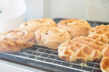 Variety of baked products at a bakery shop,pastries in a bakery window,bakery brown breads to sell,Different types of bread loaves on bakery shelves,Real photo,Template,Copy text space.