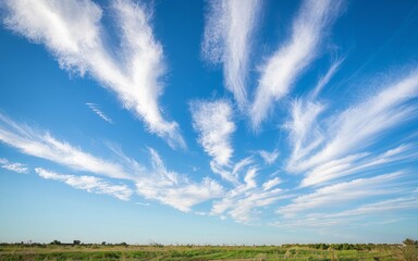 Fototapeta premium Blue sky cirrus cloudscape. Serene landscape photo; wispy cirrus clouds paint a breathtaking canvas across a vibrant blue sky. Peaceful nature scene.