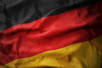 colourful waving flag of germany on the old army khaki texture background. military concept.