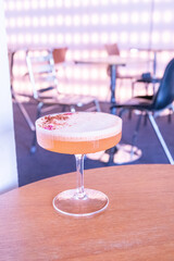 Glass of Cold Orange Mocktail on table,female hand swirling red wine in wine glass,Friends cheering with wineglasses.