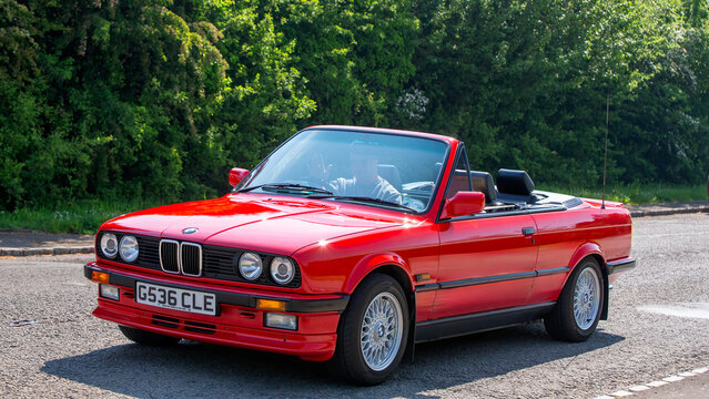 1990 red BMW 3 series 325i cabriolet  classic car driving on a British road