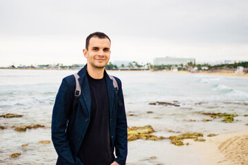 a young man on rocky coast with turquoise water of Ayia Napa, Cyprus