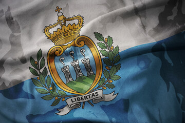 colourful waving flag of san marino on the old army khaki texture background. military concept.
